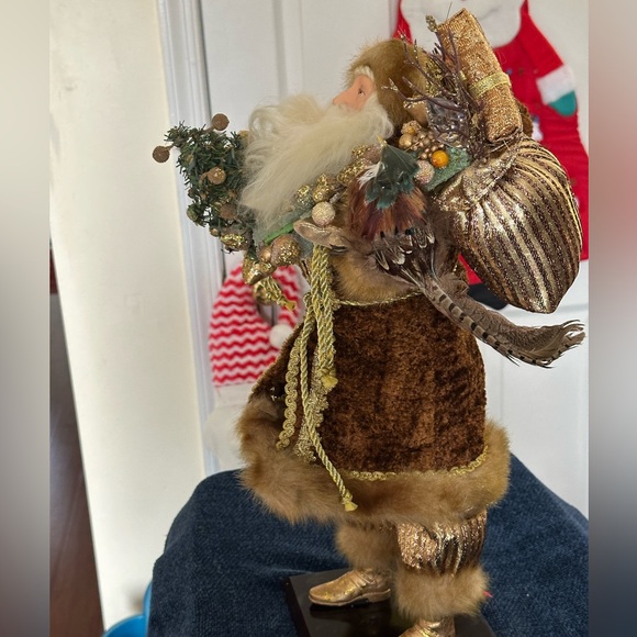 Golden velvet clad Santa holds greenery. - Picture 2 of 7